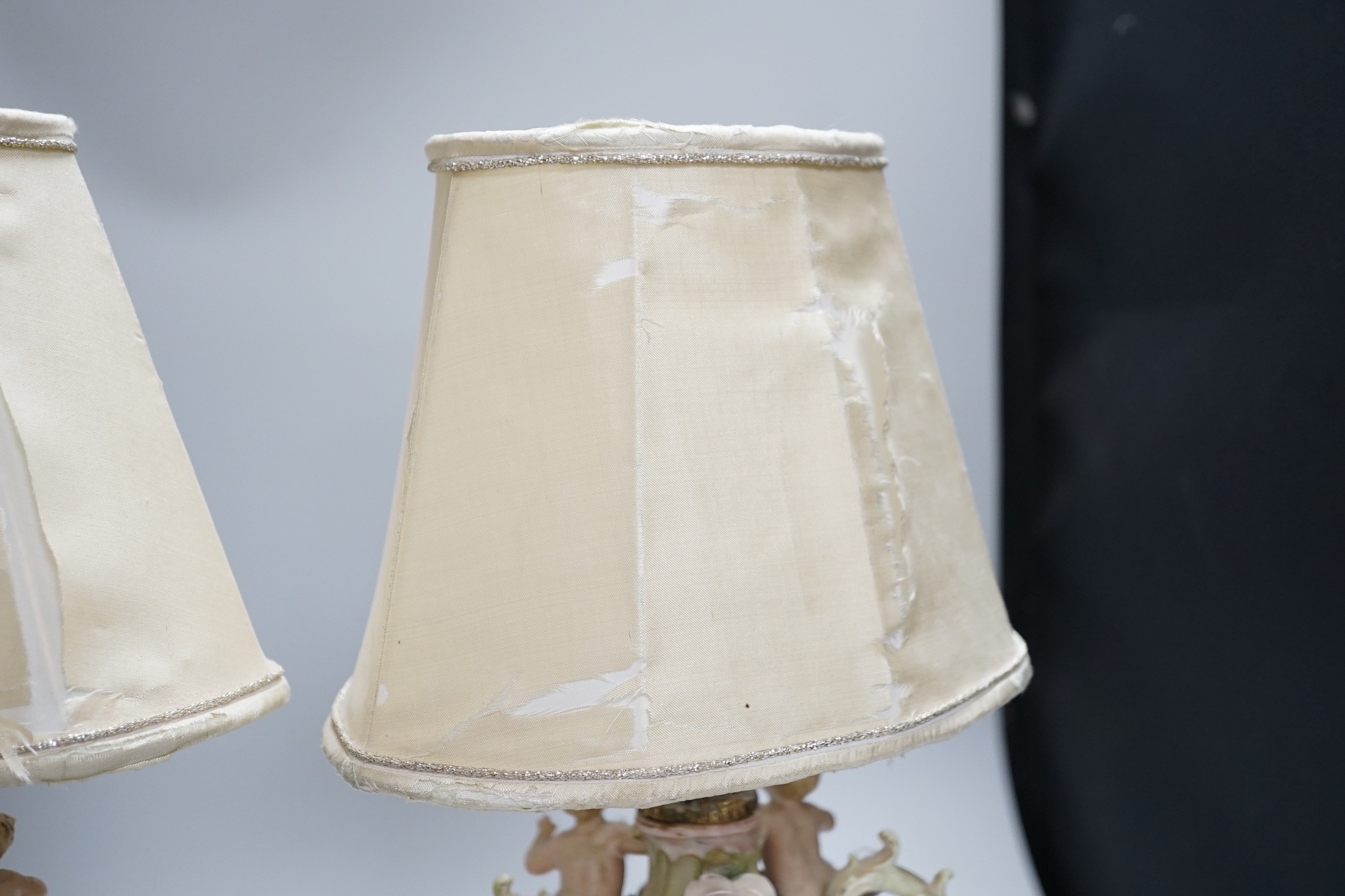 A pair of German porcelain flower encrusted lamps, height 24cm